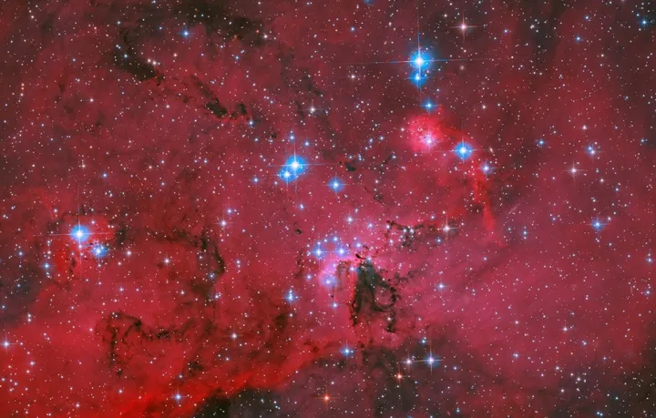 Το Hubble της NASA απαθανατίζει ένα κατακόκκινο νέφος που λάμπει από λευκά και γαλάζια άστρα